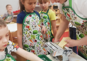 pani Justyna wkłada pasek ciasta do maszynki
